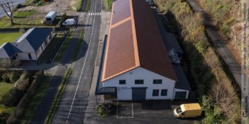 Le bâtiment des services techniques de Rives-en-Seine (76) couvert de tuiles solaires Edilians